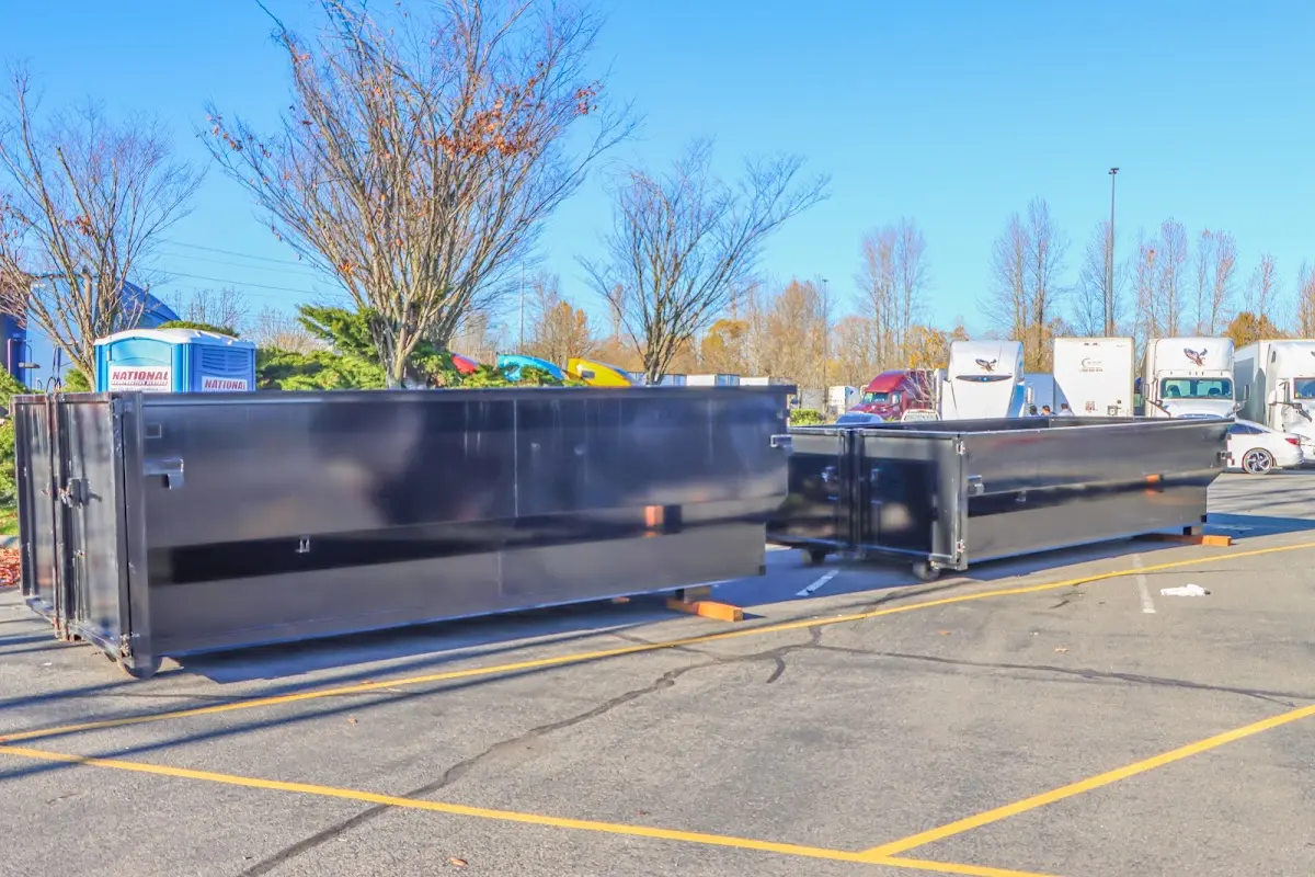 Professional dumpster rental service with roll-off container on residential driveway in Hamilton